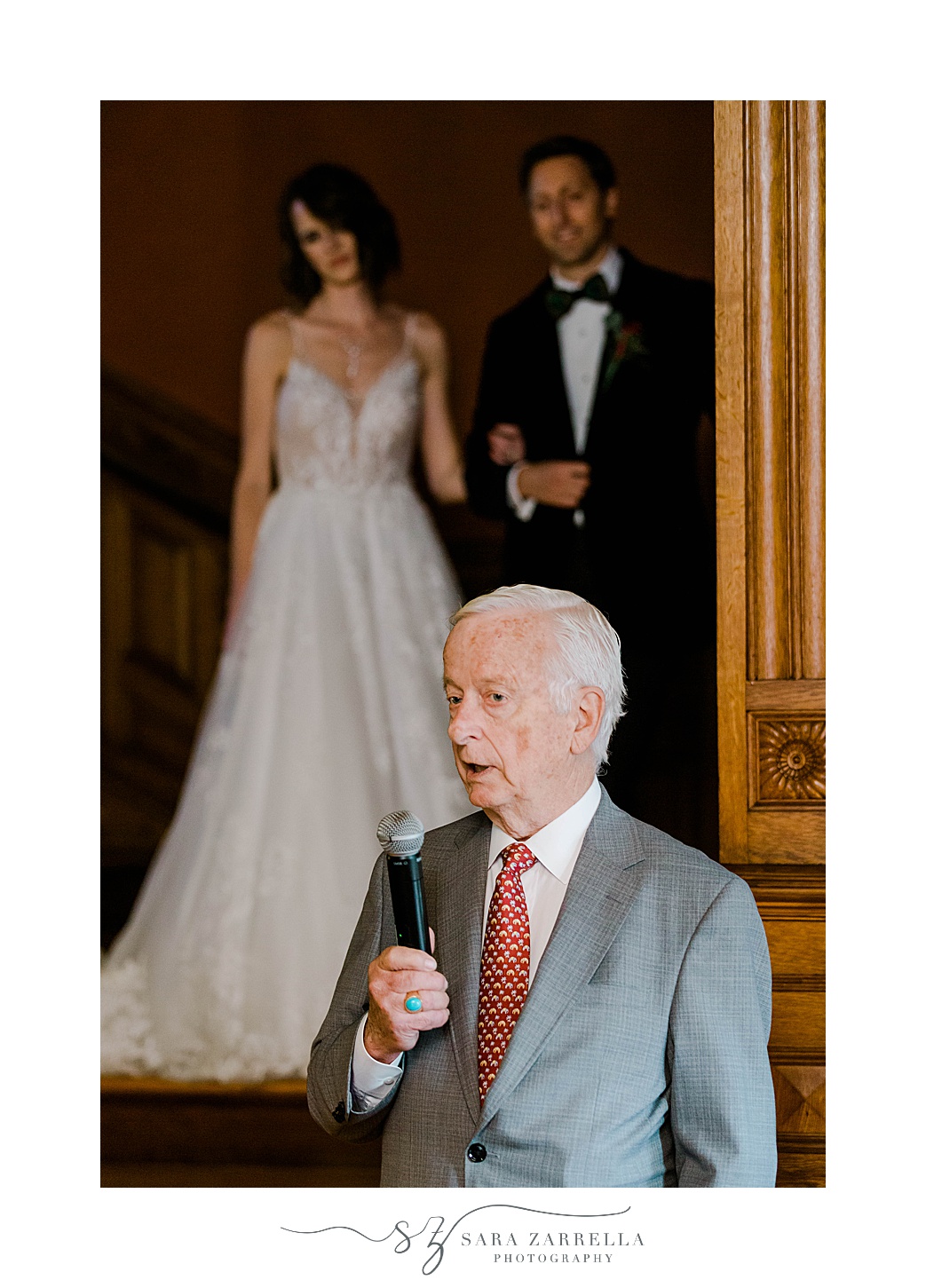 father gives speech while bride and groom look on