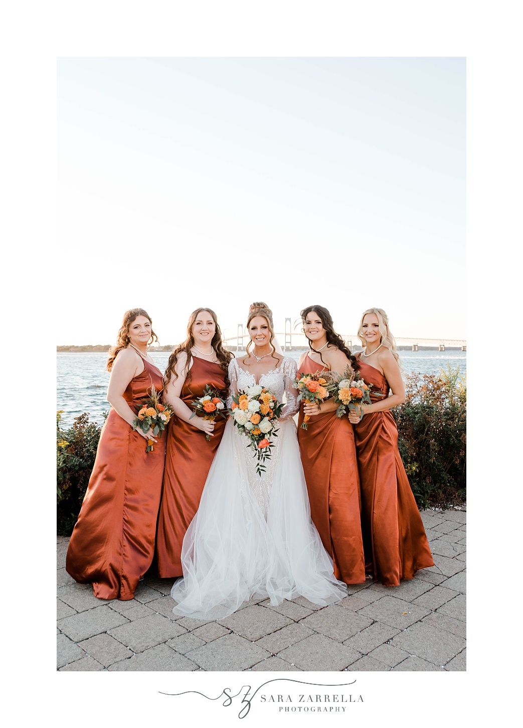 bride and bridesmaids stand alongside waterfront in Newport RI 
