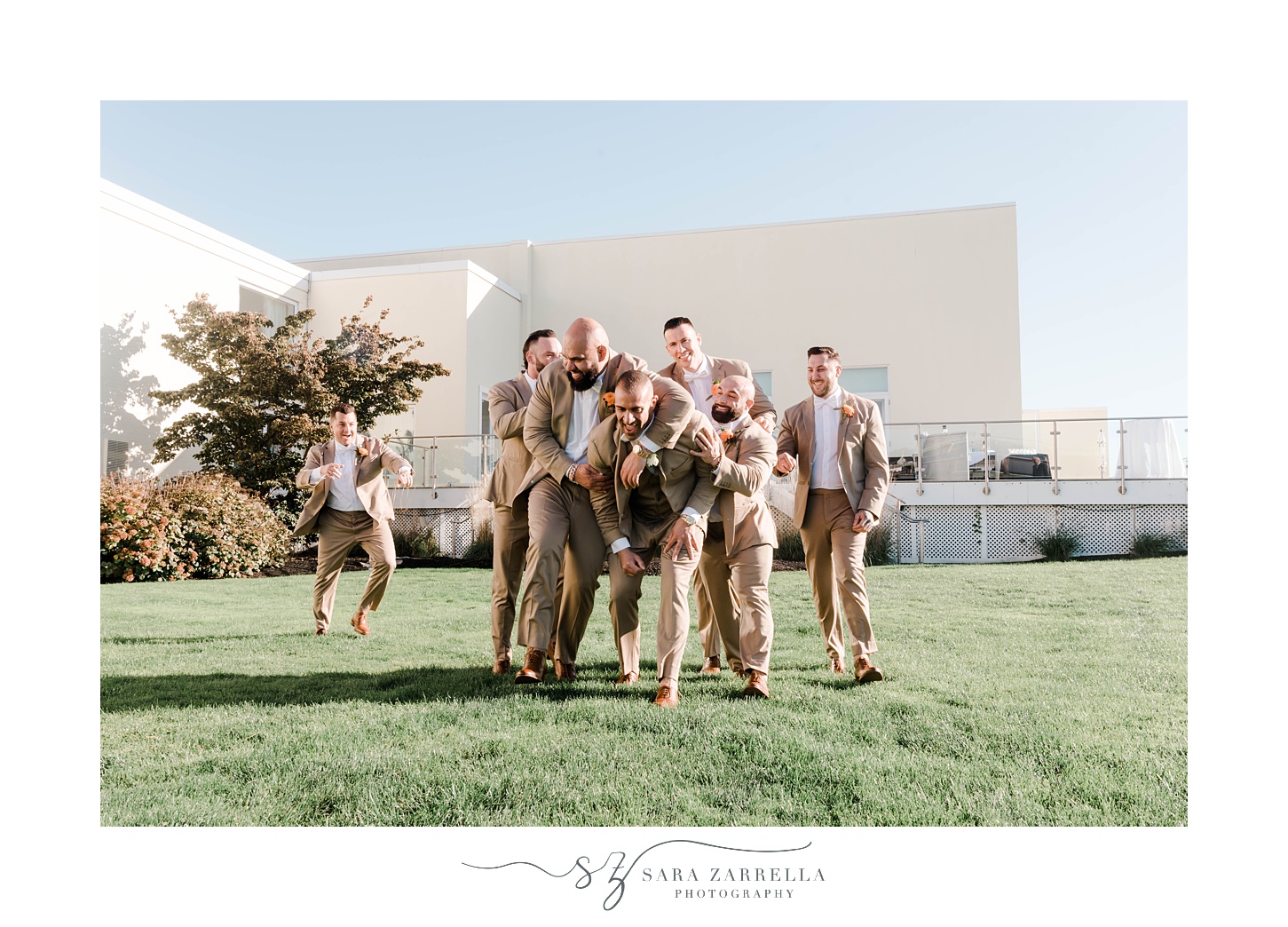 groom laughs with groomsmen in tan suits at Newport Harbor Island Resort