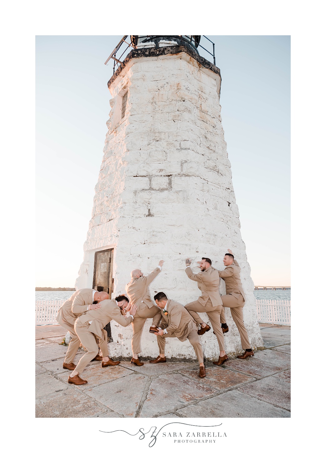 groom and groomsmen pretend to climb lighthouse in Newport RI