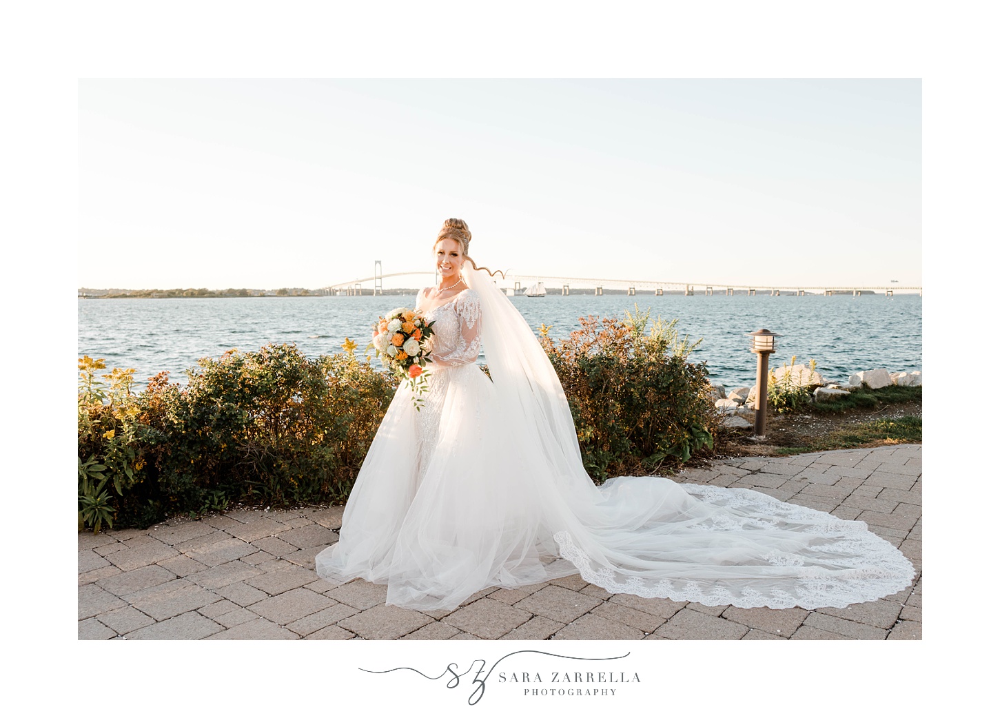 bride poses by waterfront outside Newport Harbor Island Resort
