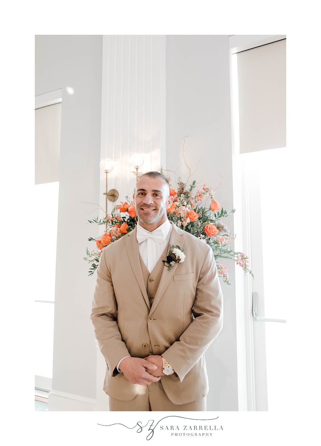 groom stands by floral arrangement in Newport RI