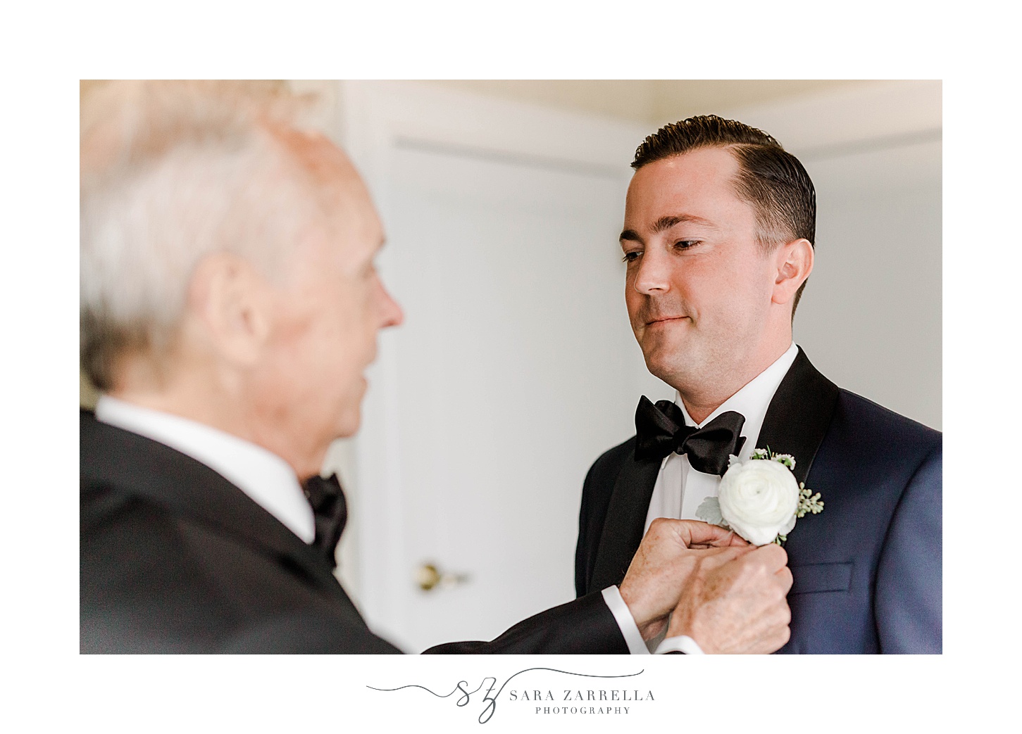 dad helps groom with white rose boutonnière 