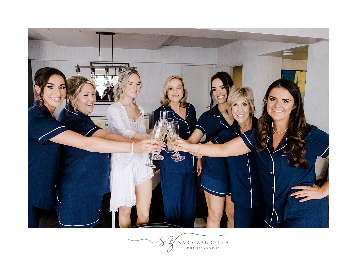 bride and bridesmaids toast champagne in navy pajamas 