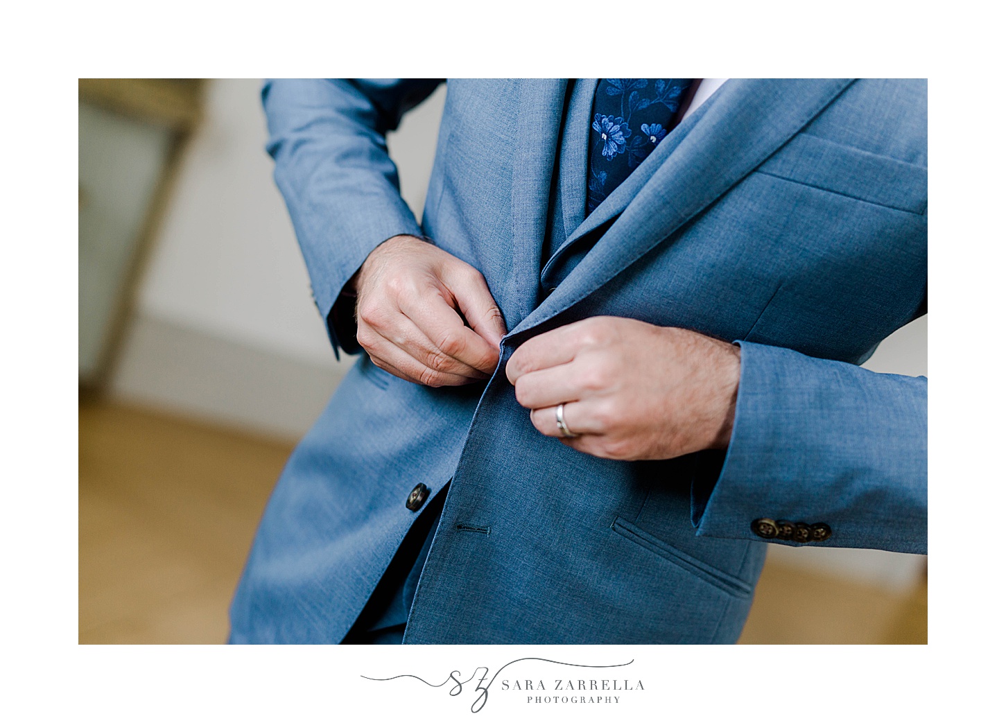 groom buttons jacket on blue suit before Rosecliff Mansion wedding