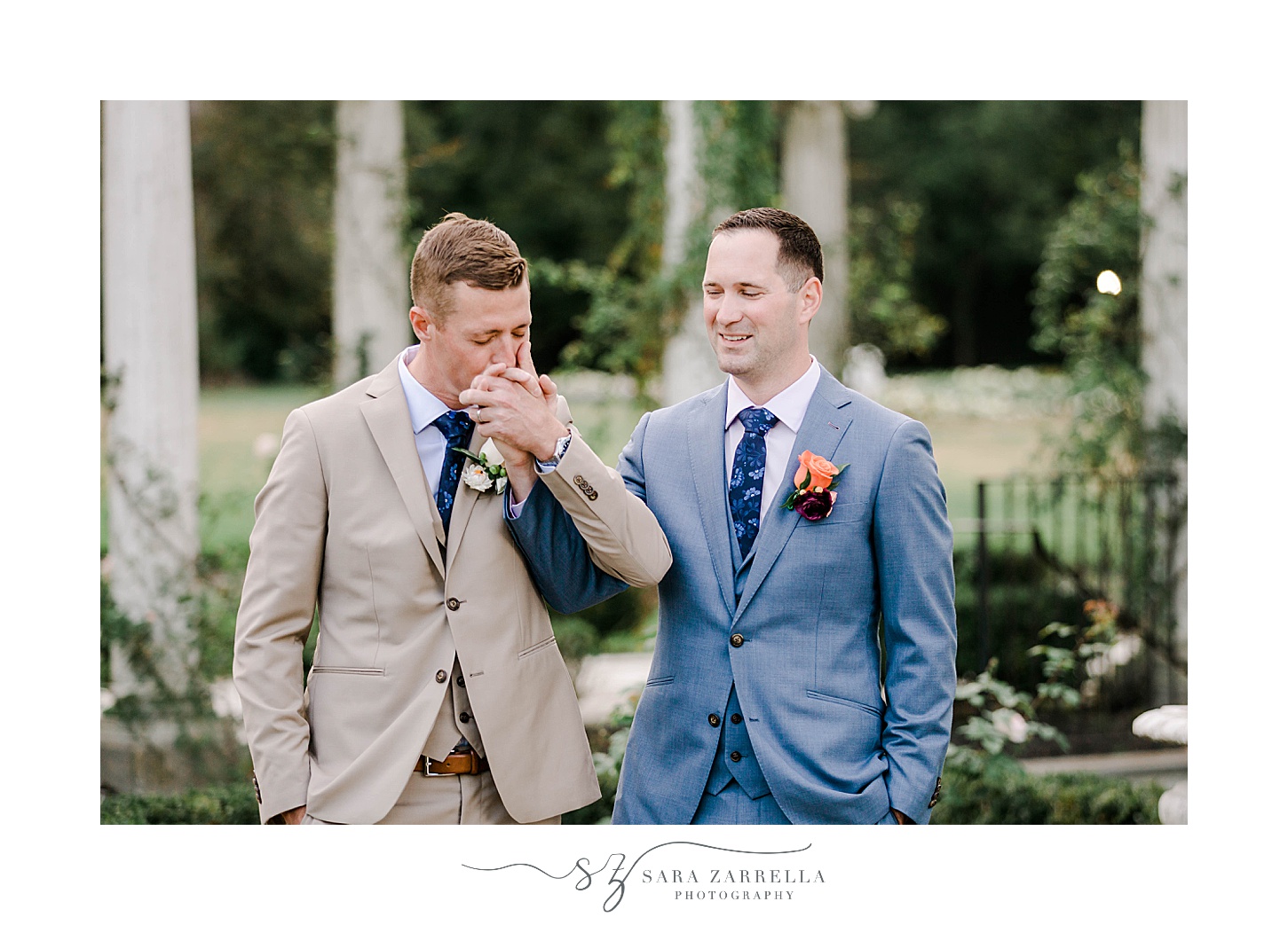 groom kisses husband's hand in gardens in Newport RI