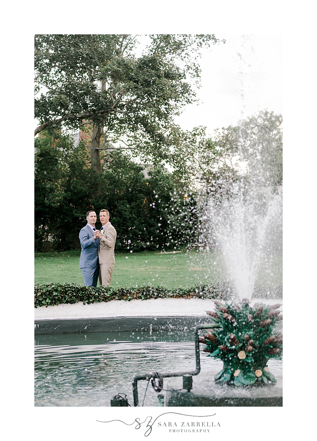 couple hugs behind fountain in Rhode Island