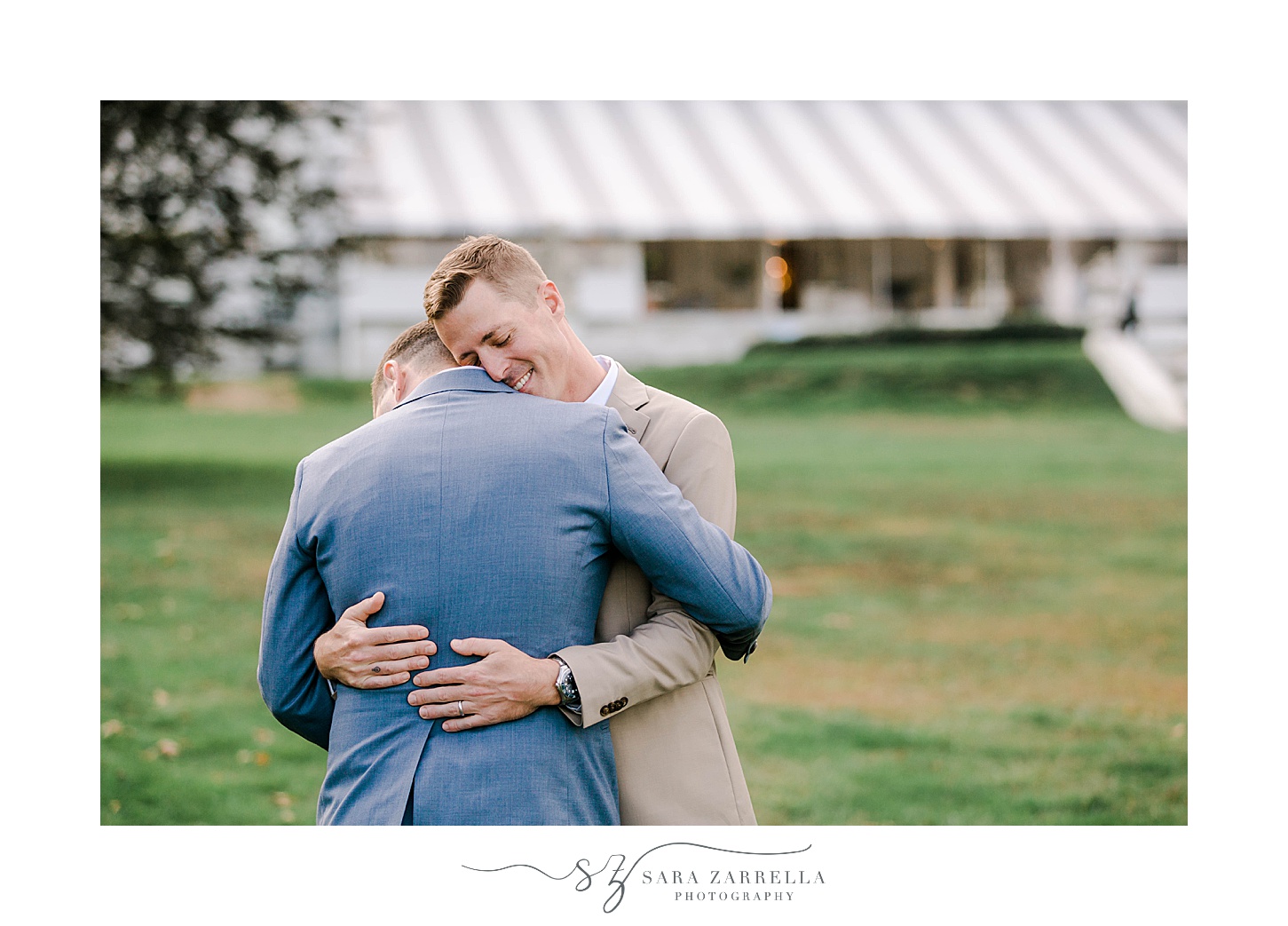 grooms hug on lawn at Rosecliff Mansion
