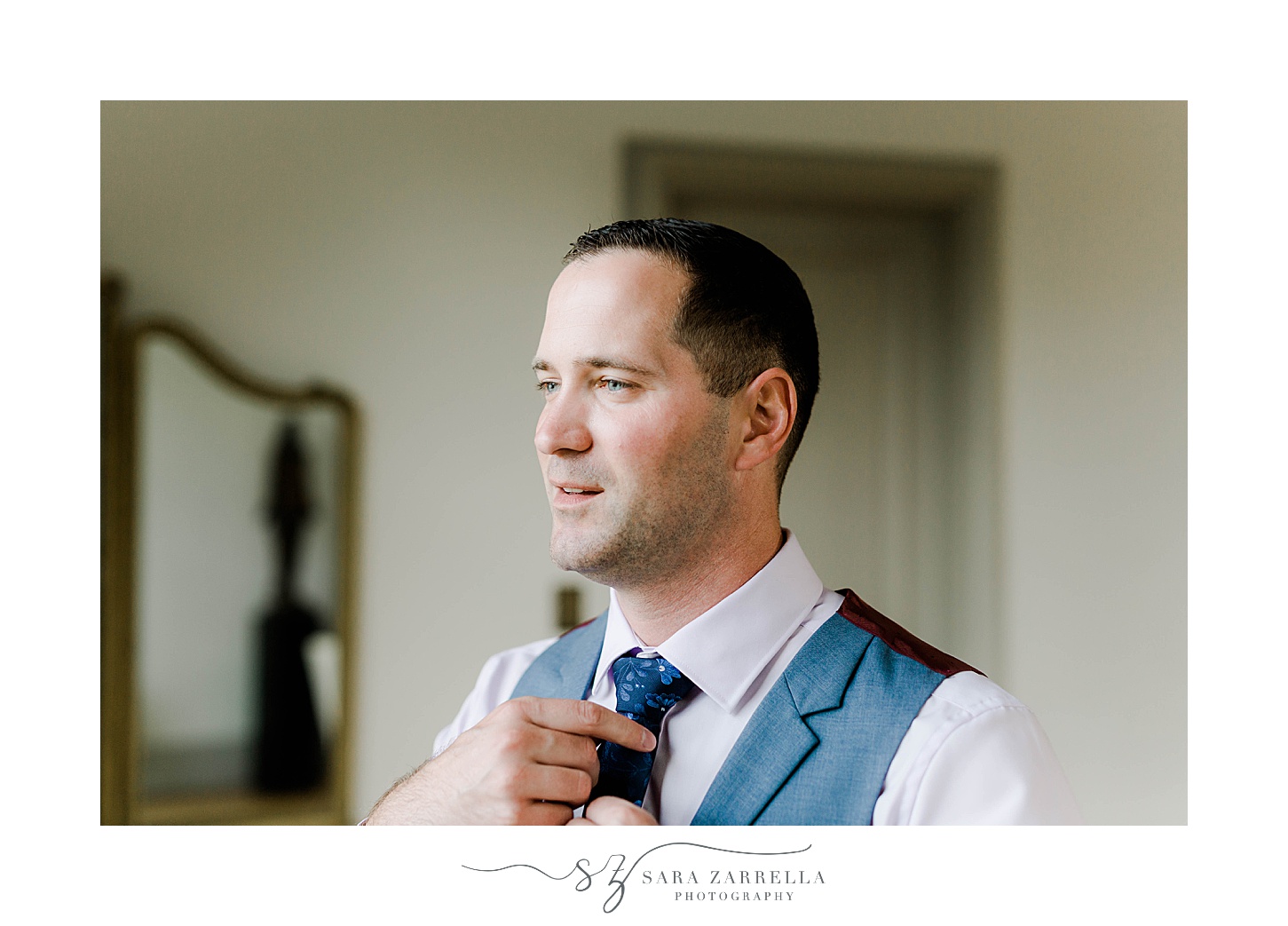 groom adjusts tie before Rosecliff Mansion wedding