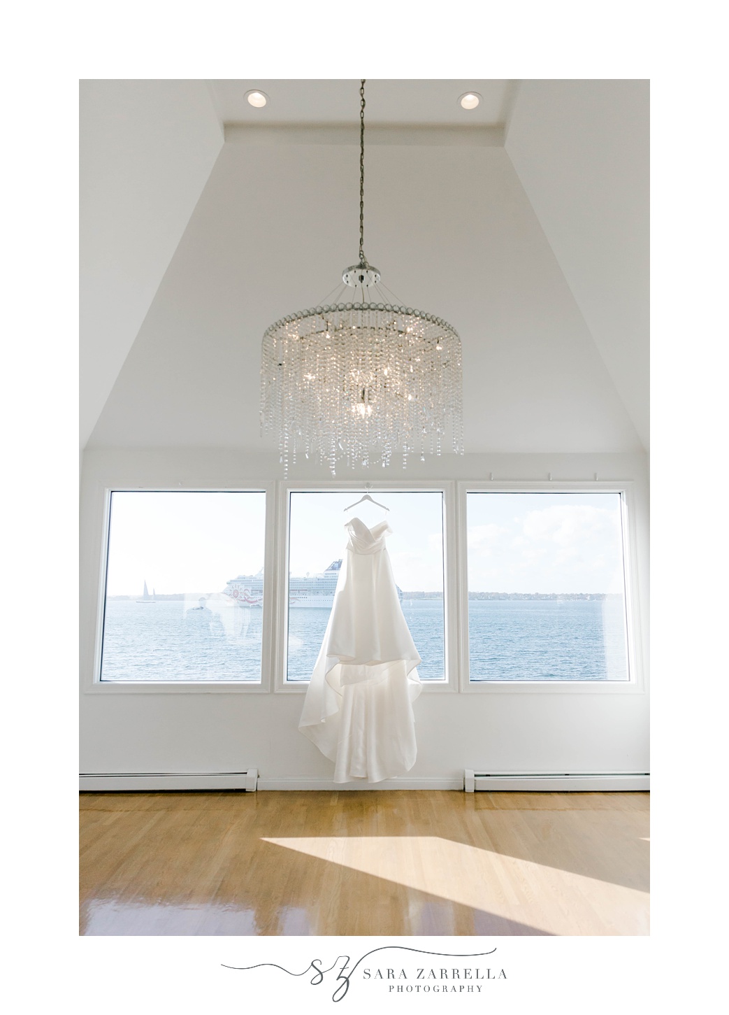 wedding dress hangs in window of bridal suite at Belle Mer