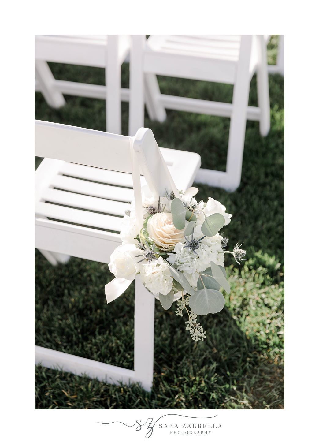 flowers hang on folding white chair for ceremony 