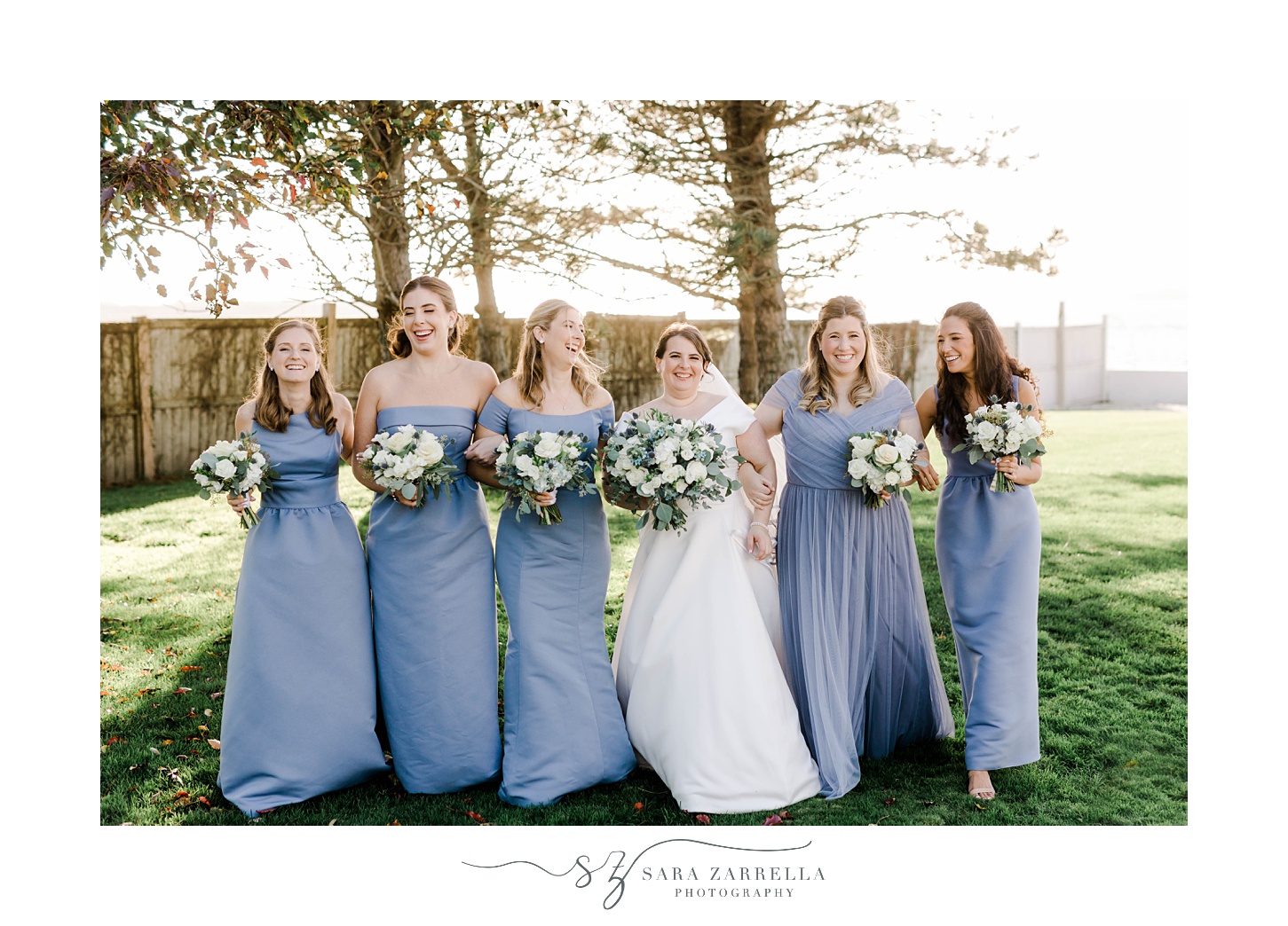 bride walks with bridesmaids in light blue gowns 