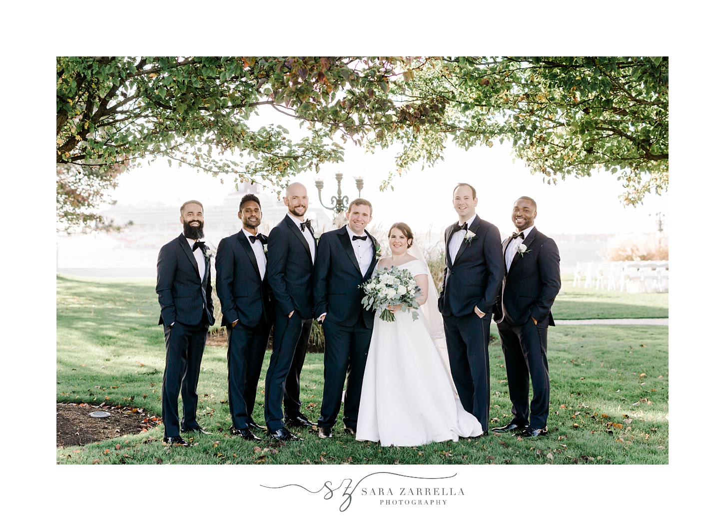 groomsmen in classic suits with blue jackets stand with bride 