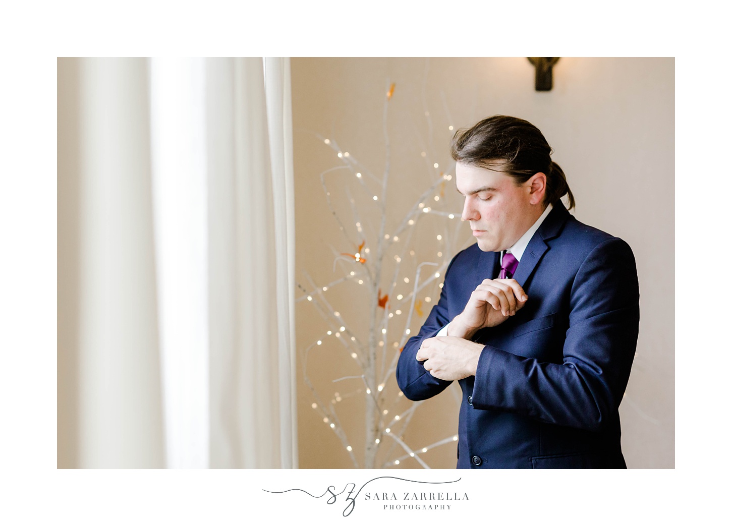 groom adjusts cufflinks of blue suit at Foster Country Club