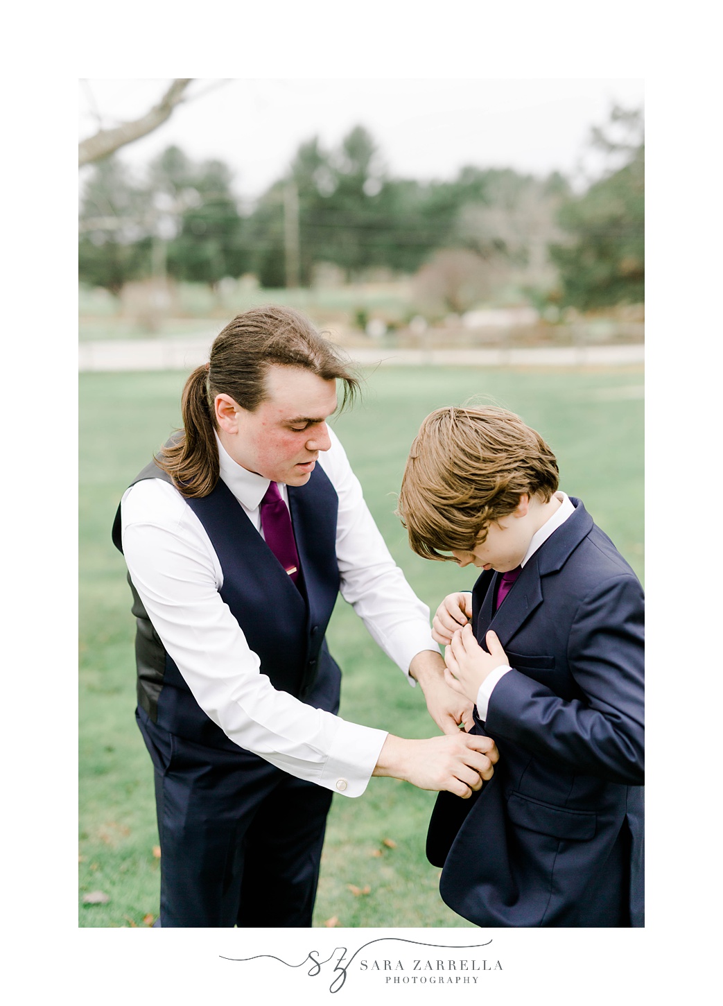 groom helps brother with jacket 