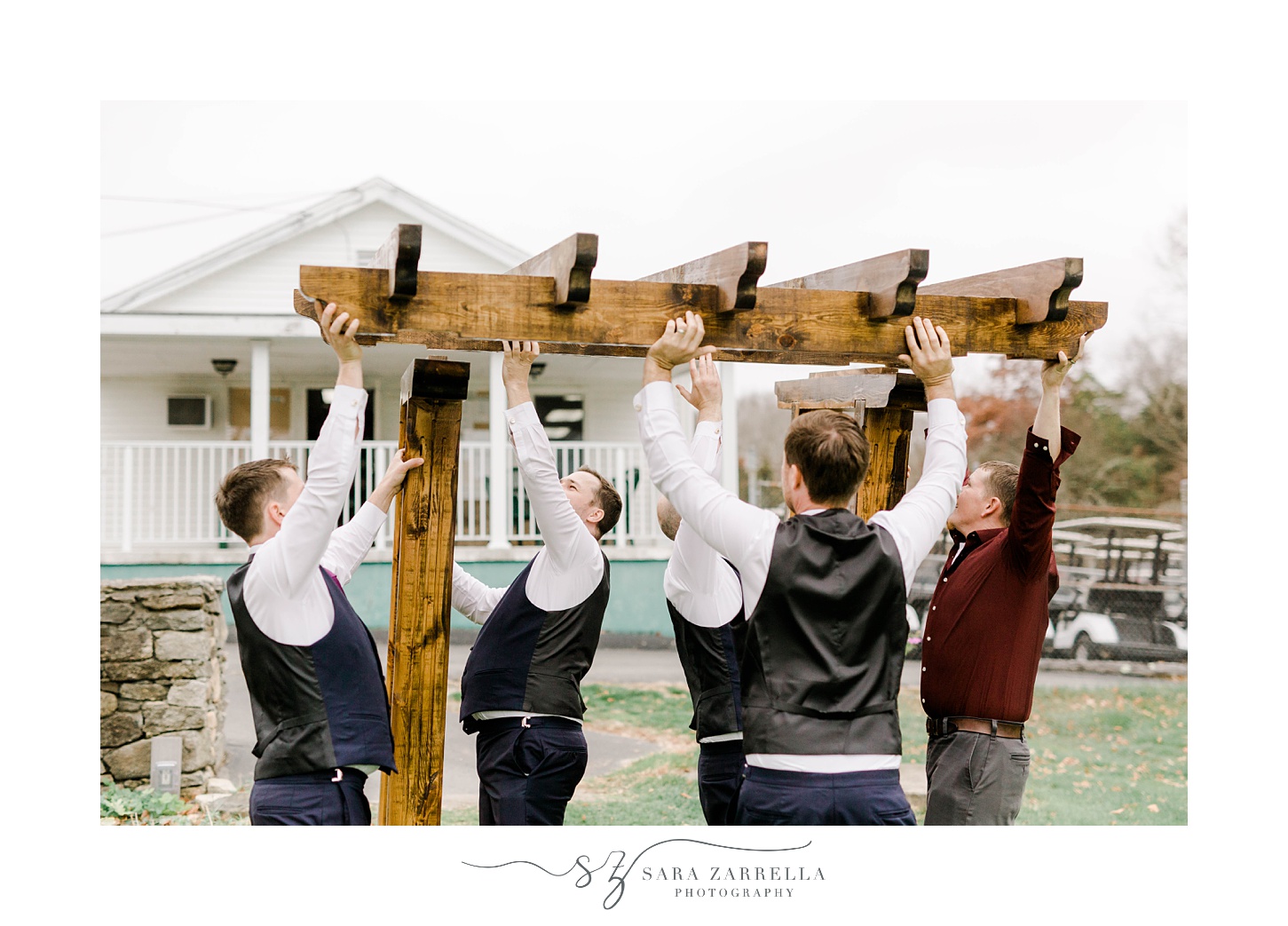 groom and groomsmen lift up wedding arbor at Foster Country Club