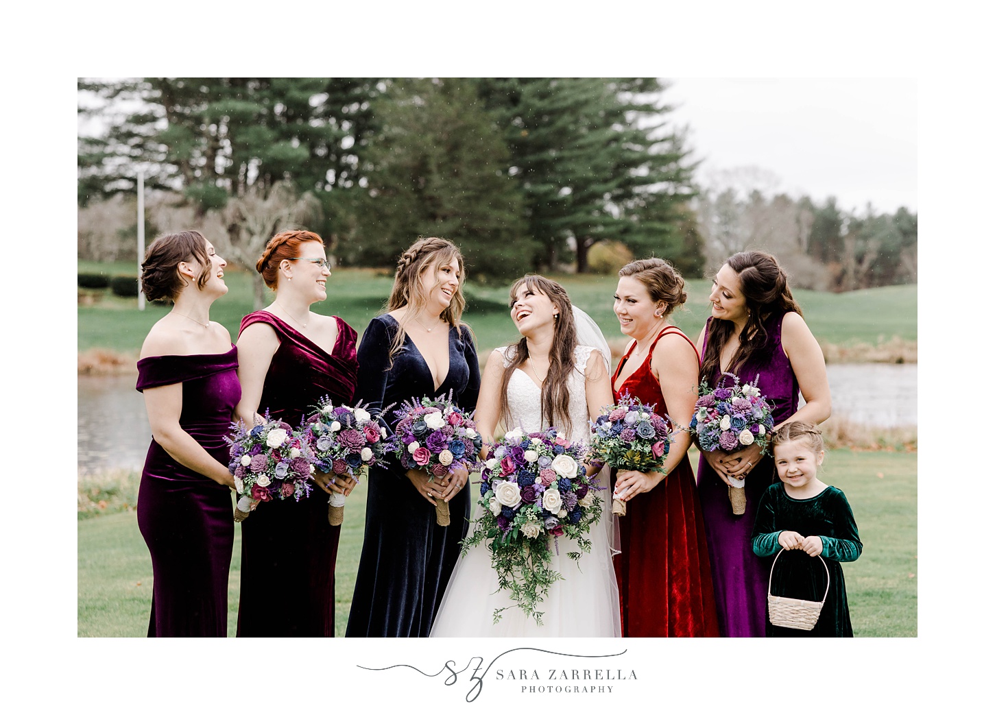 bride smiles at bridesmaids in jewel-tone velvet gowns 