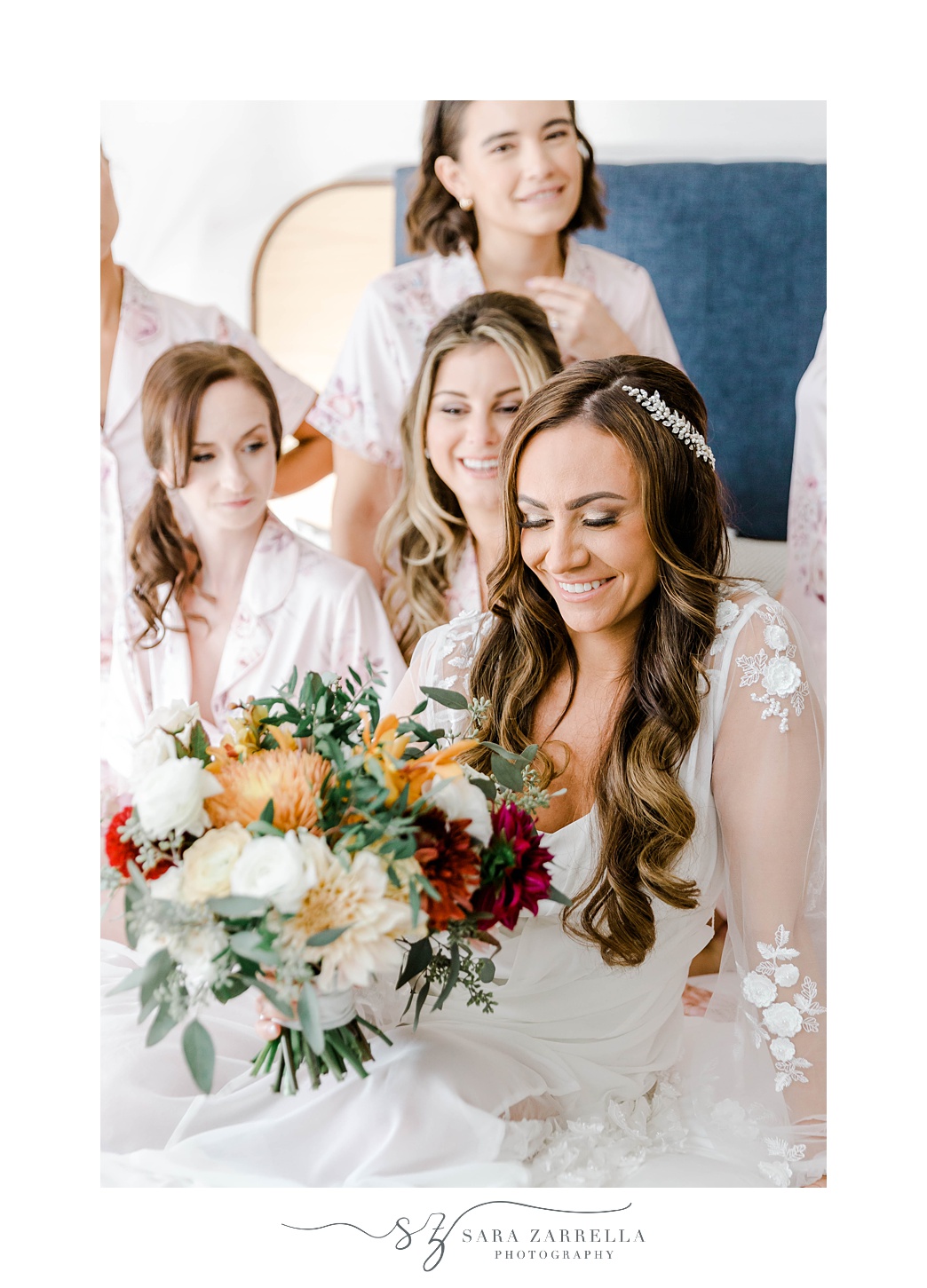 bride and bridesmaids sit on bed in bridal suite at Newport Harbor Island Resort
