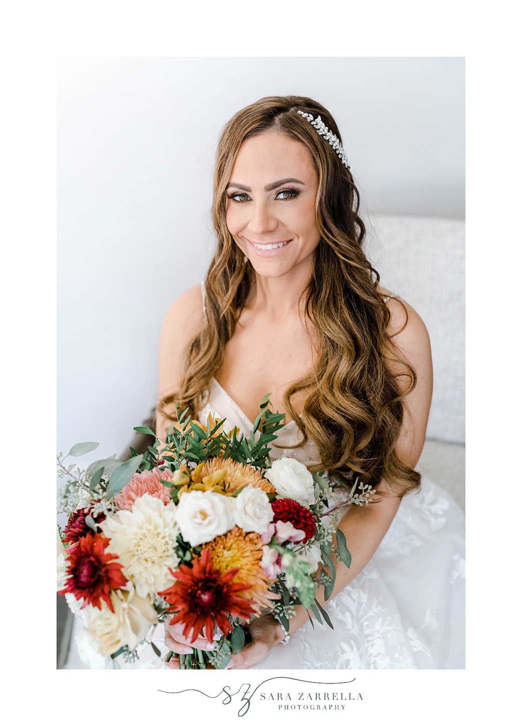 bride smiles holding bouquet of fall flowers