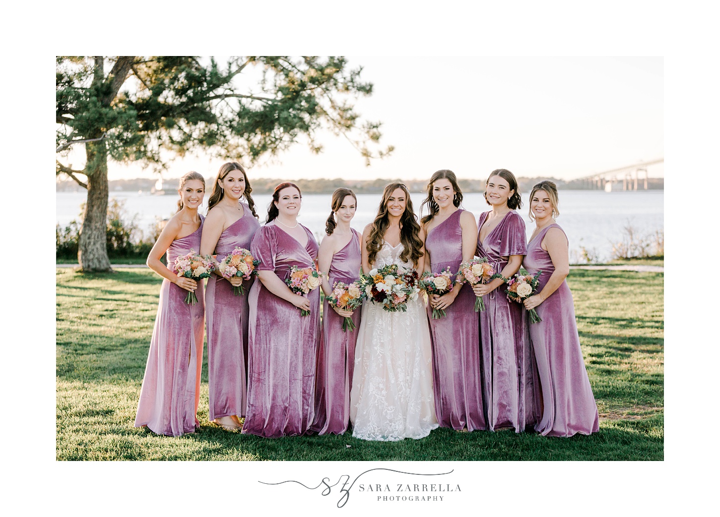 bride stands with bridesmaids in pink velvet gowns