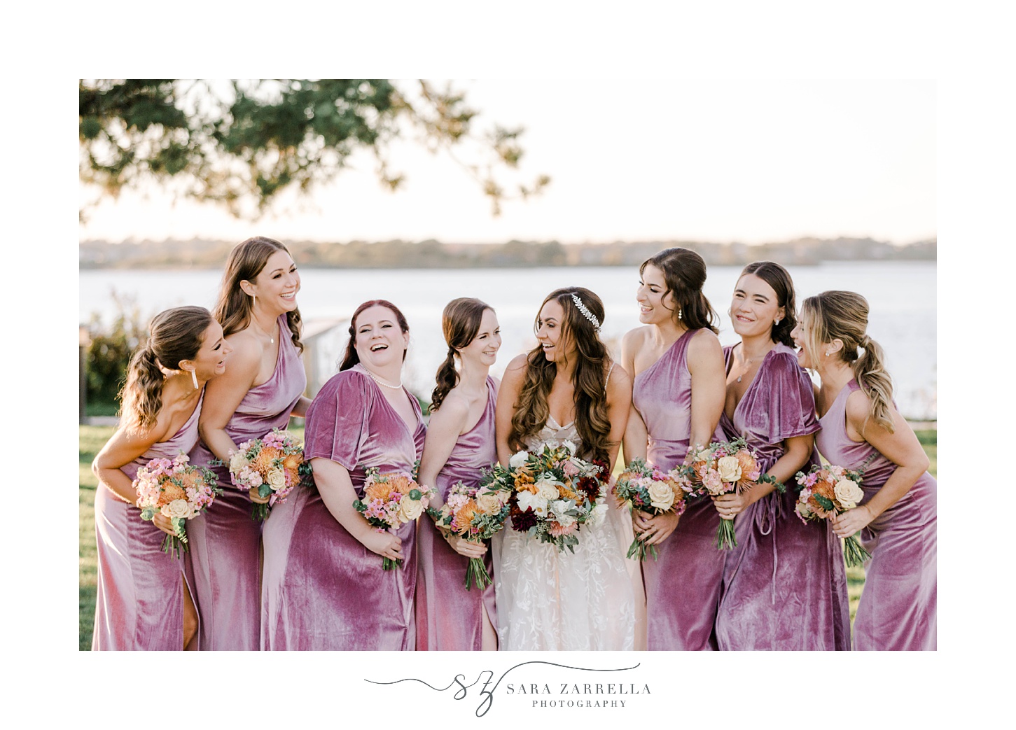 bride smiles looking at bridesmaids in pink velvet gowns for fall wedding