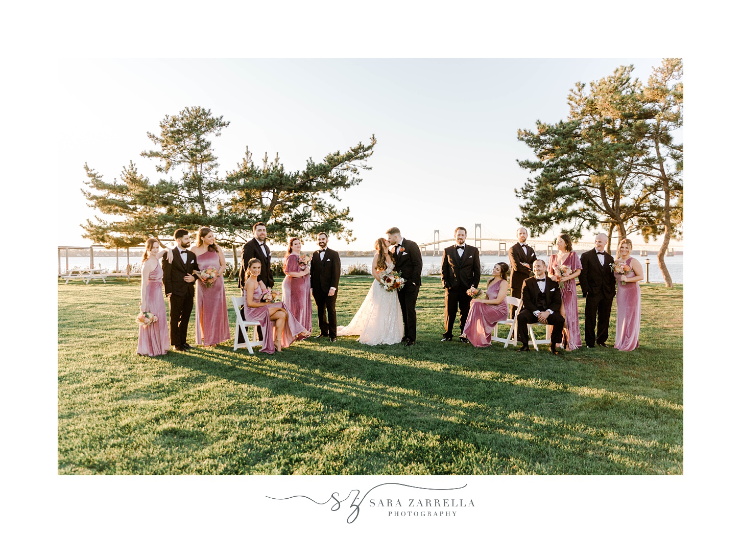 bride and groom stand with wedding party on lawn at Newport Harbor Island Resort