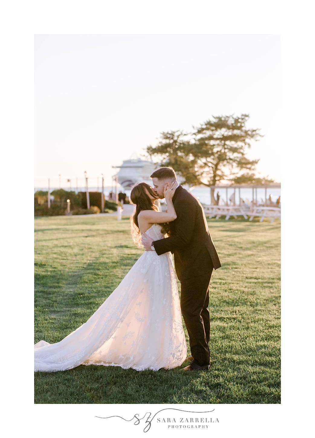 newlyweds kiss at sunset on lawn at Newport Harbor Island Resort