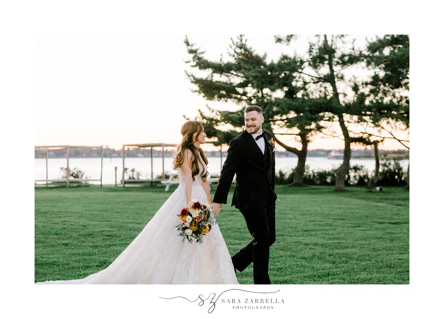 groom leads bride across lawn at Newport Harbor Island Resort