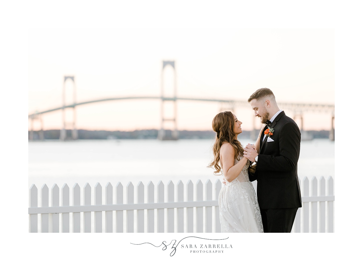 bride and groom smile in front of Newport Bridge 