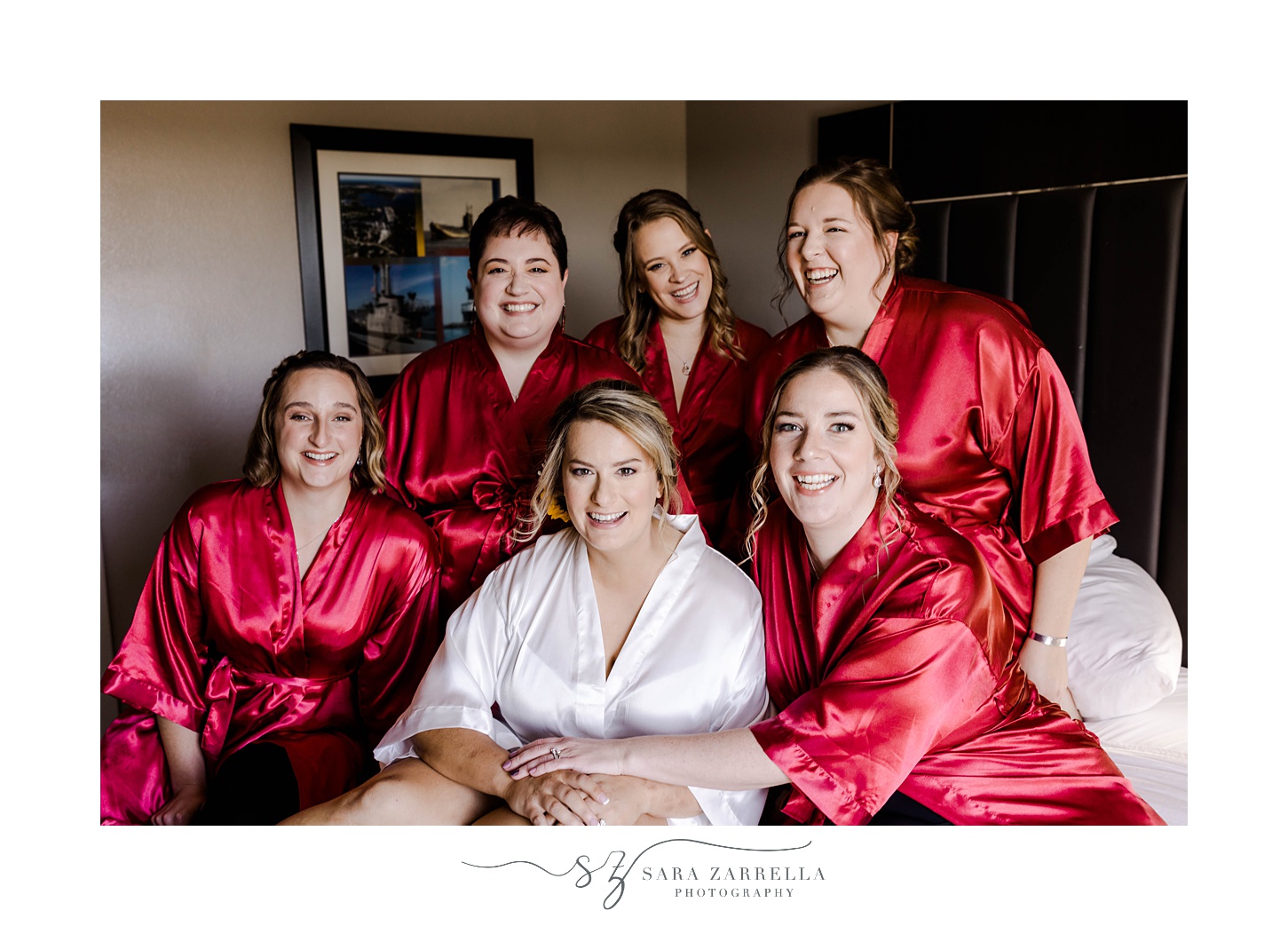 bride sits with bridesmaids in red robes at Quidnessett Country Club