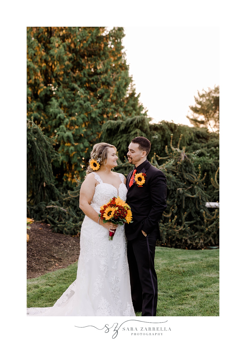 bride and groom hug with sunflowers in bouquet and in boutonniere  at Quidnessett Country Club