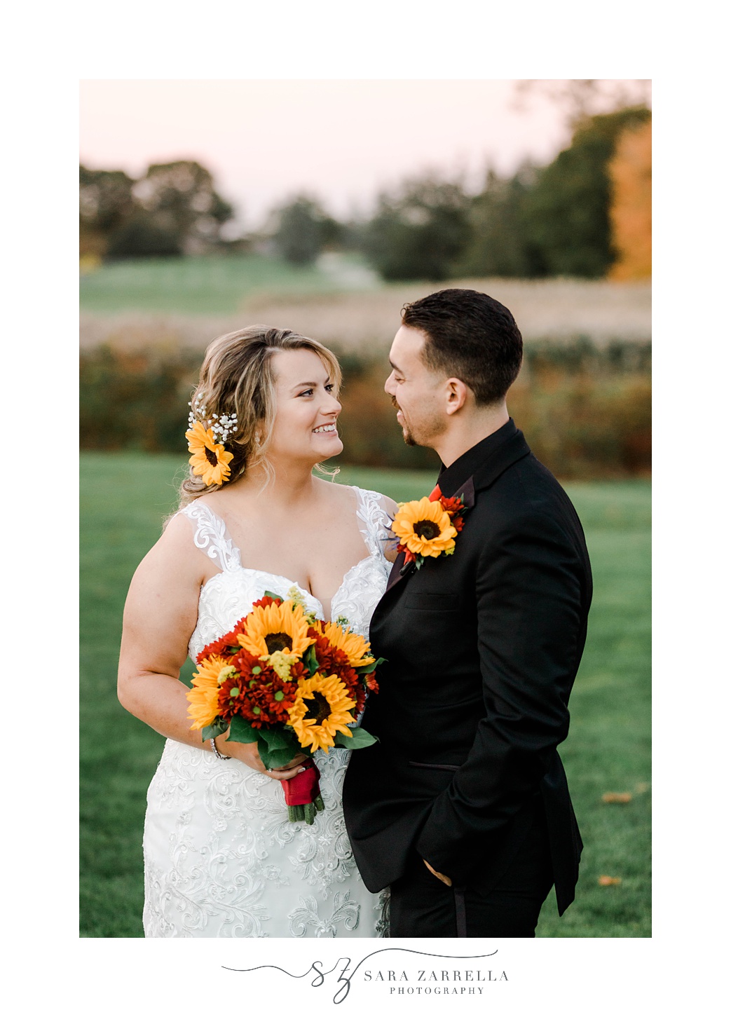 bride and groom hug smiling at each other with sunflower accents