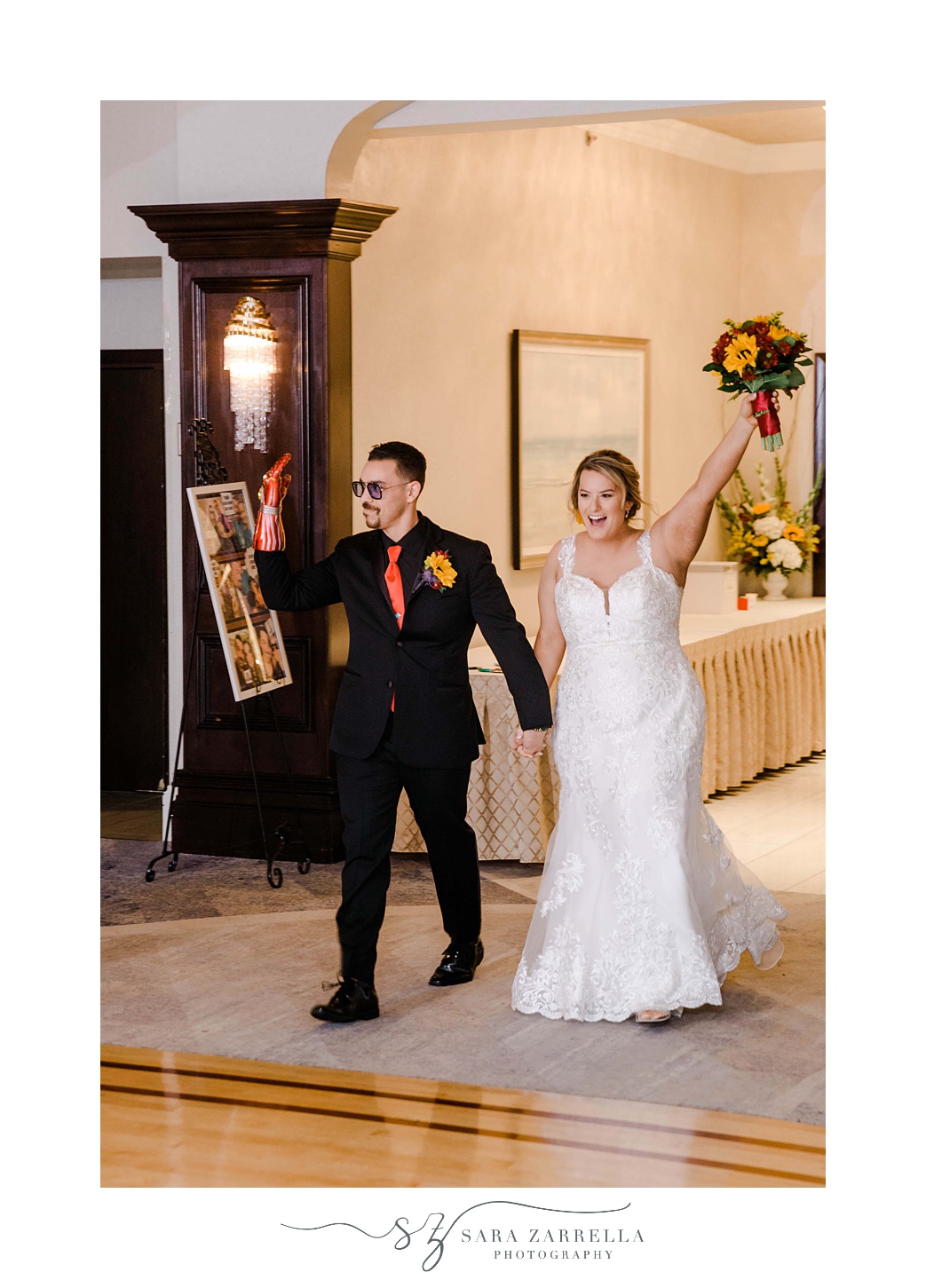 bride and groom cheer walking into reception at Quidnessett Country Club