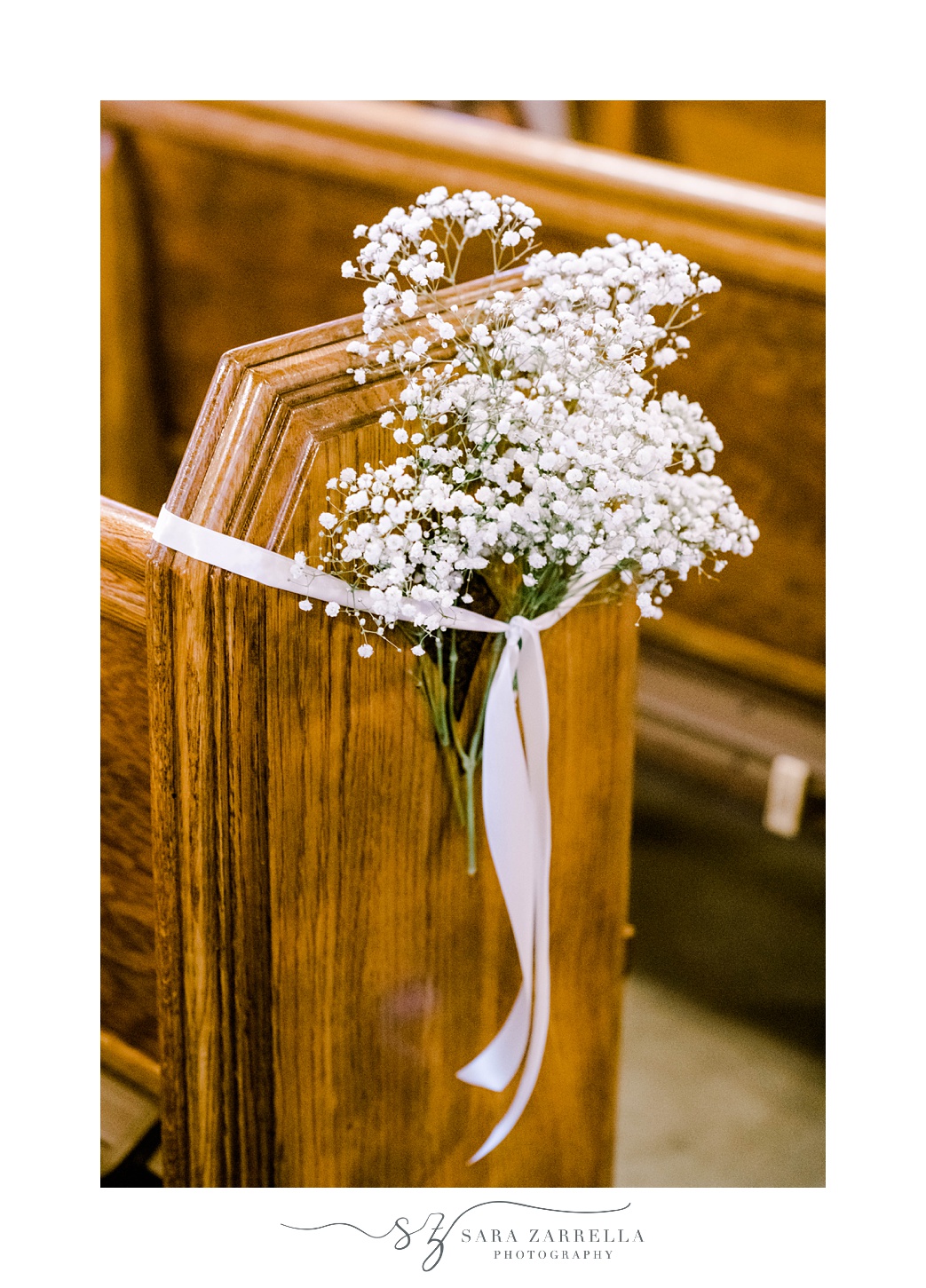 baby's breath held to wooden pew with ribbon 