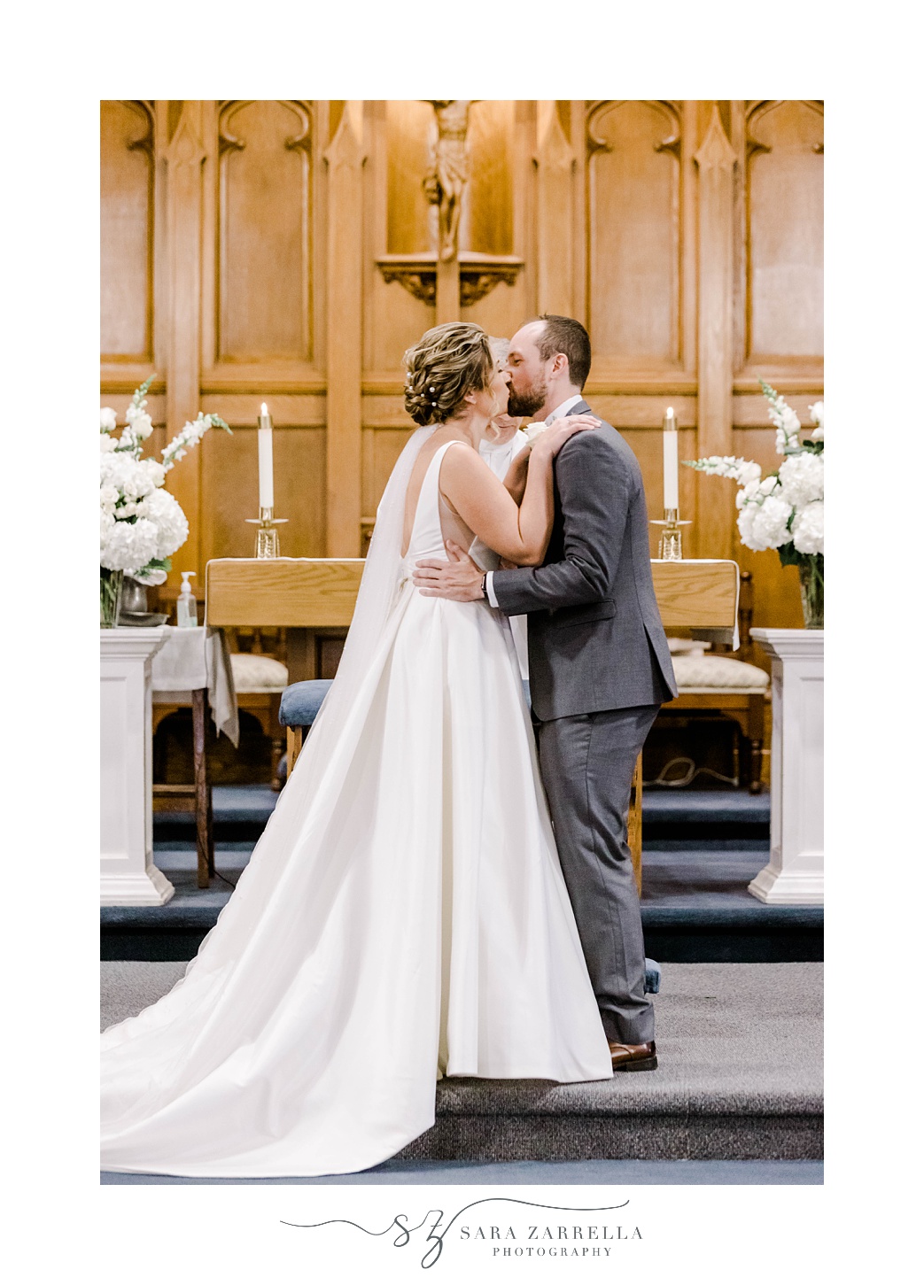 bride and groom kiss during  traditional church ceremony in Rhode Island 