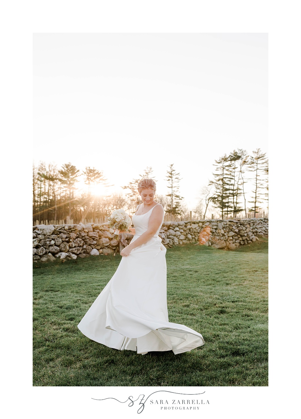 bride twirls wedding gown on lawn by brick wall at Shepard's Run