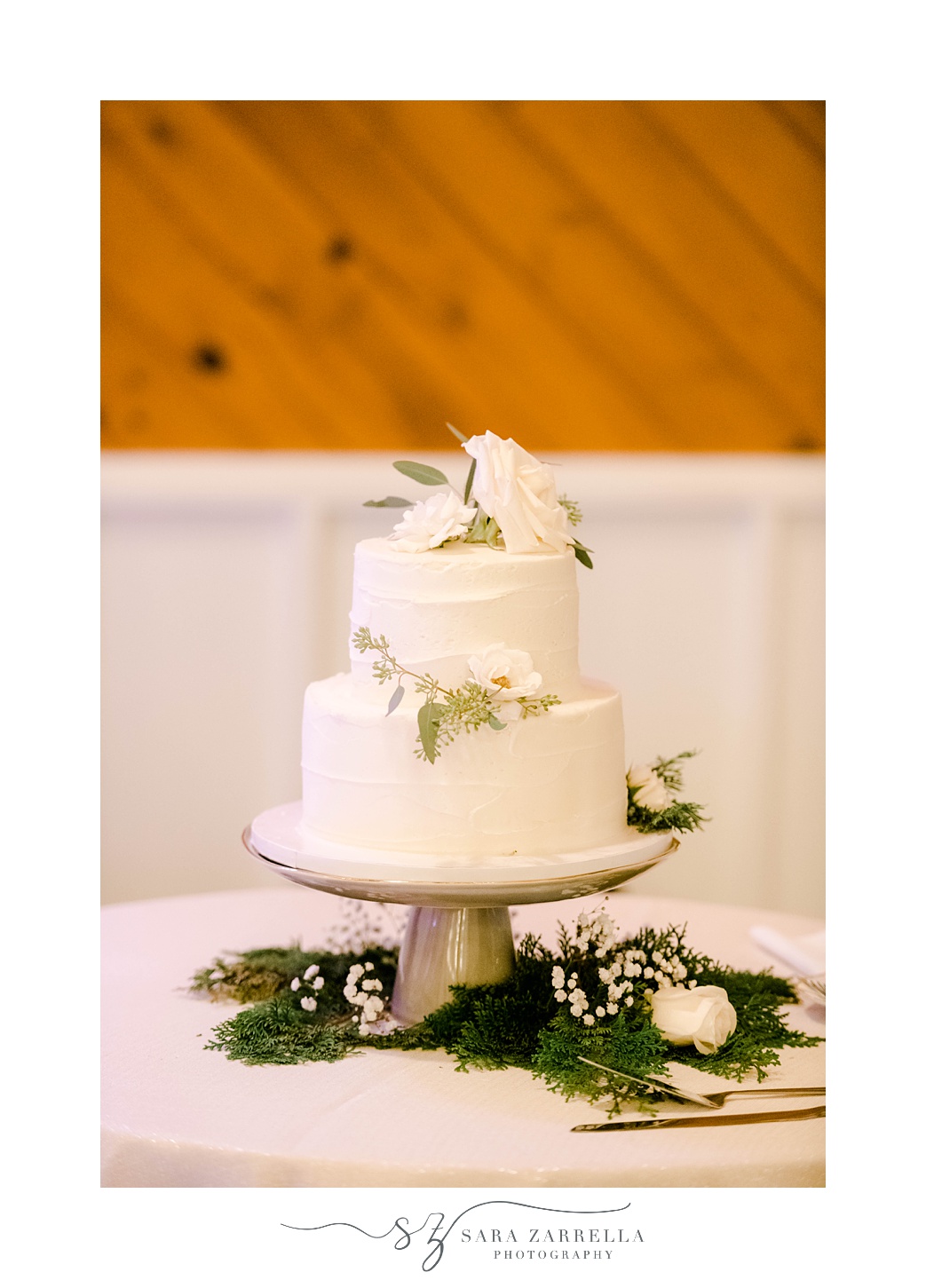 two-tiered wedding cake with white flower accents 