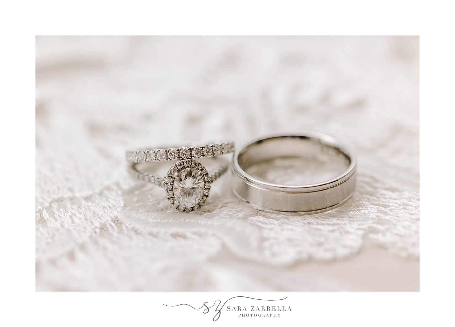 silver wedding bands rest on lace of veil