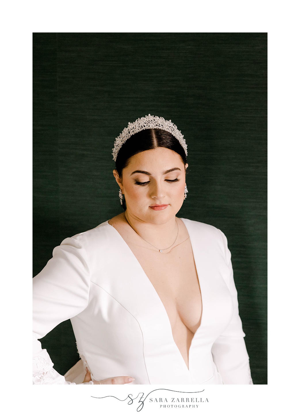 bride poses in long-sleeve gown with white pearl headband 