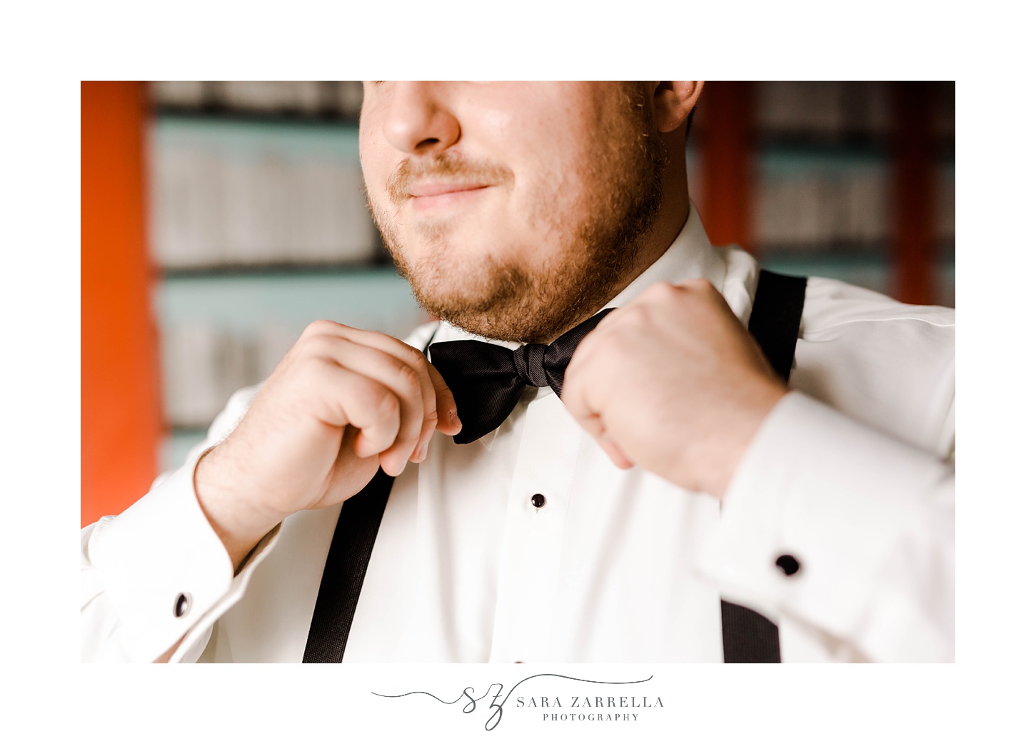 groom adjusts black bow tie before Rhode Island wedding day