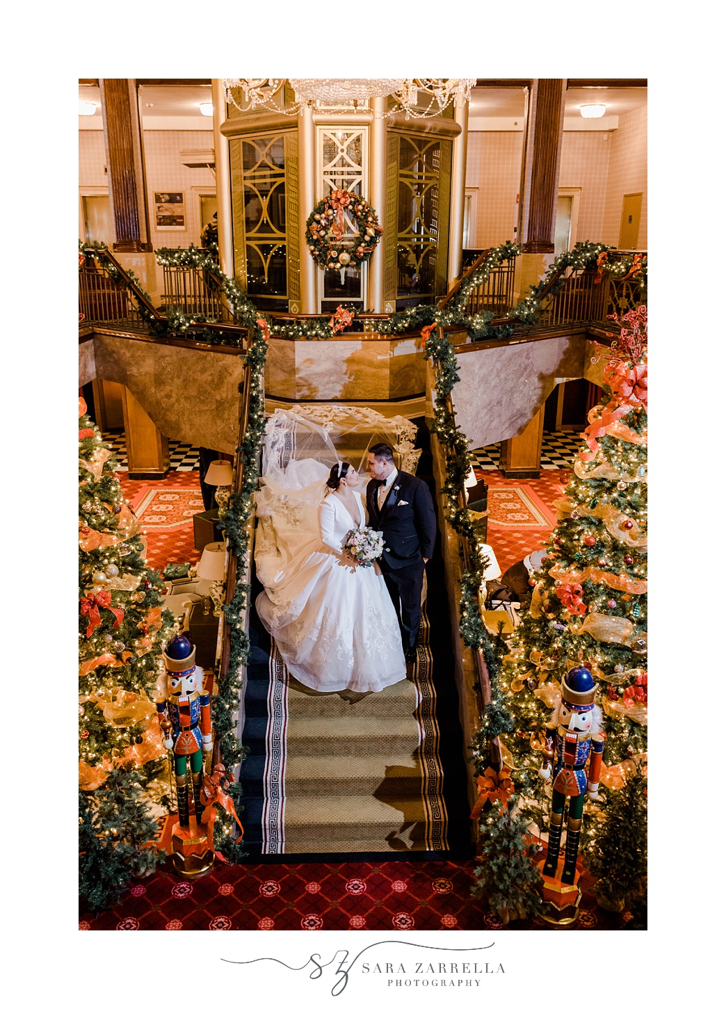 newlyweds pose on steps with bride's dress draped behind them at The Graduate Providence