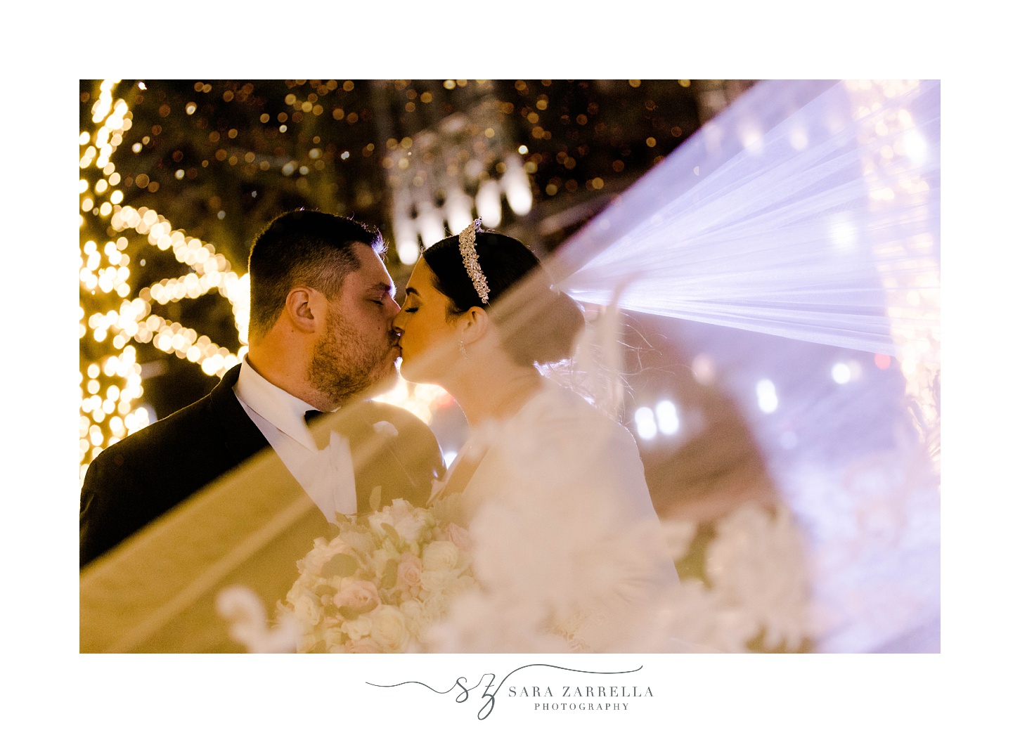 newlyweds kiss with bride's veil floating around them