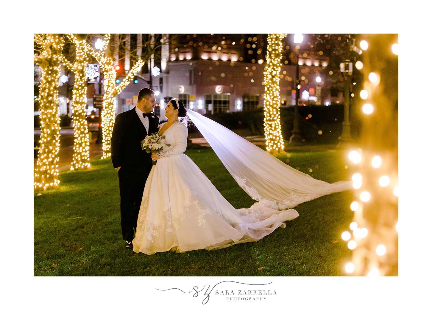 bride and groom walk through Providence RI park with trees lined with Christmas lights