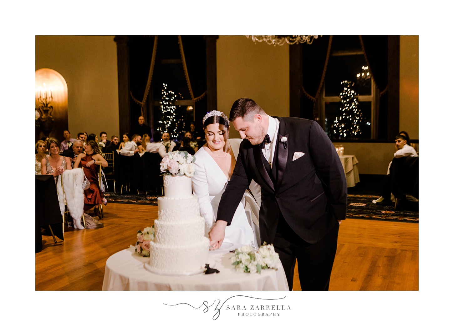 newlyweds cut wedding cake in center of ballroom