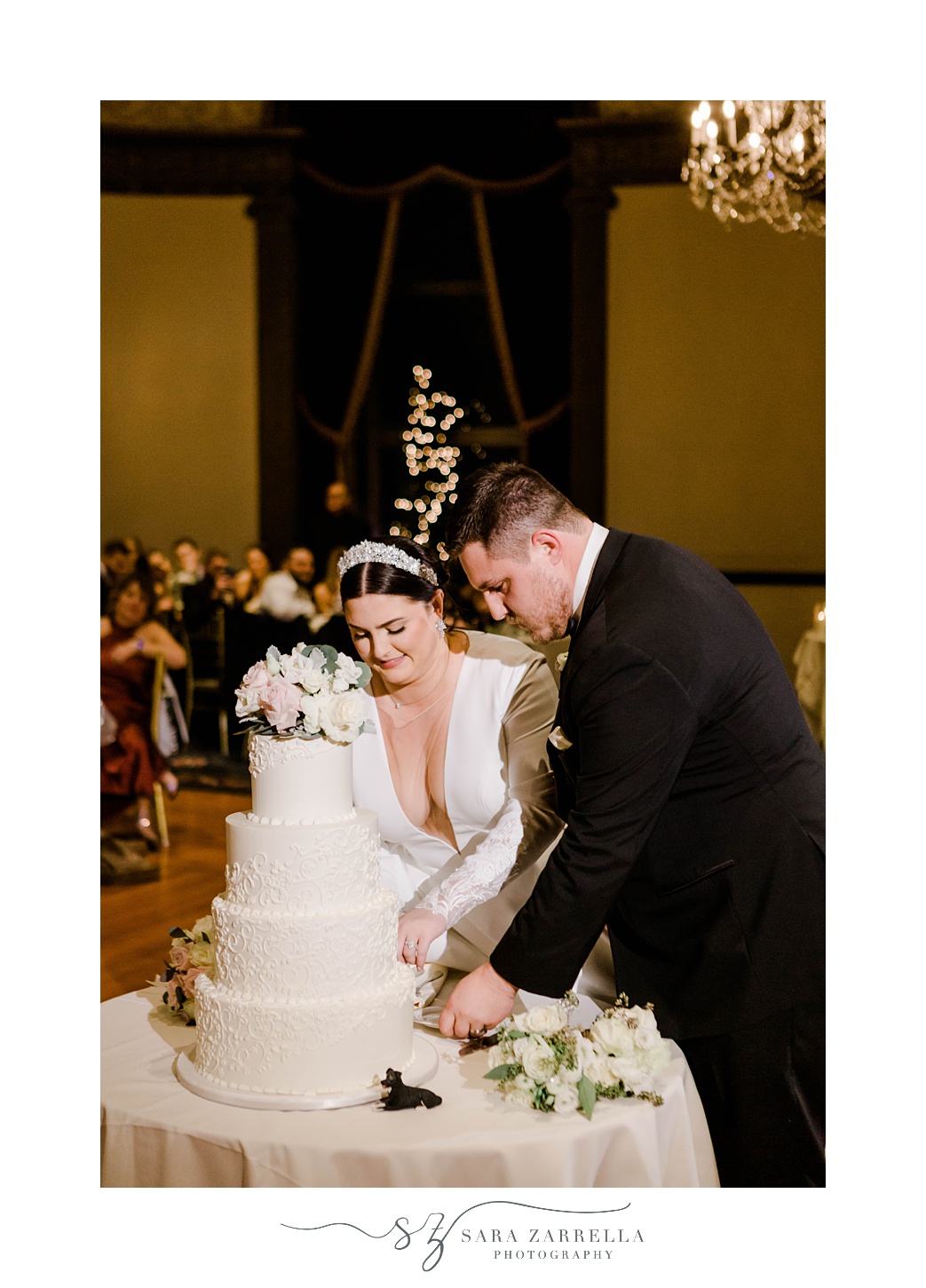 newlyweds cut wedding cake in center of ballroom