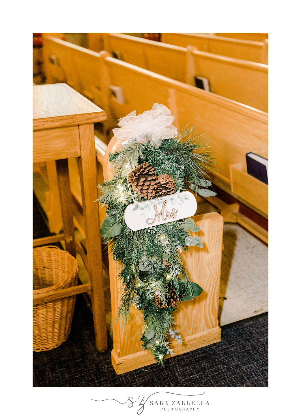 Mrs sign hangs with greenery and pine cone in traditional Catholic church in Rhode Island