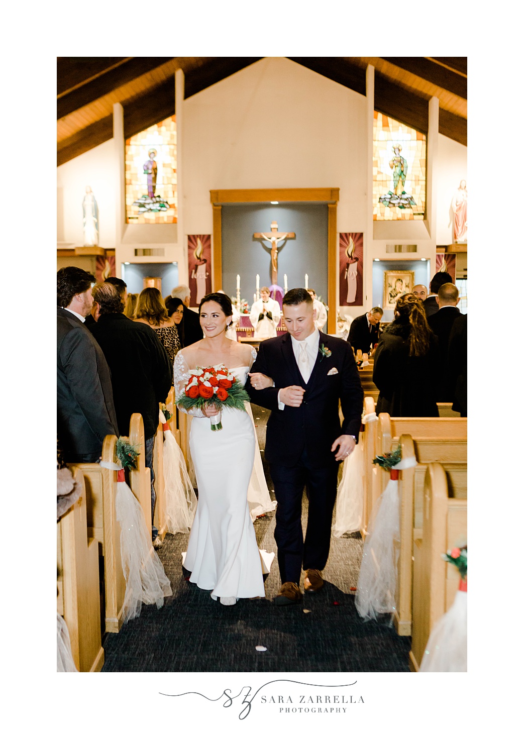 bride and groom recess up aisle after traditional Catholic ceremony in Rhode Island