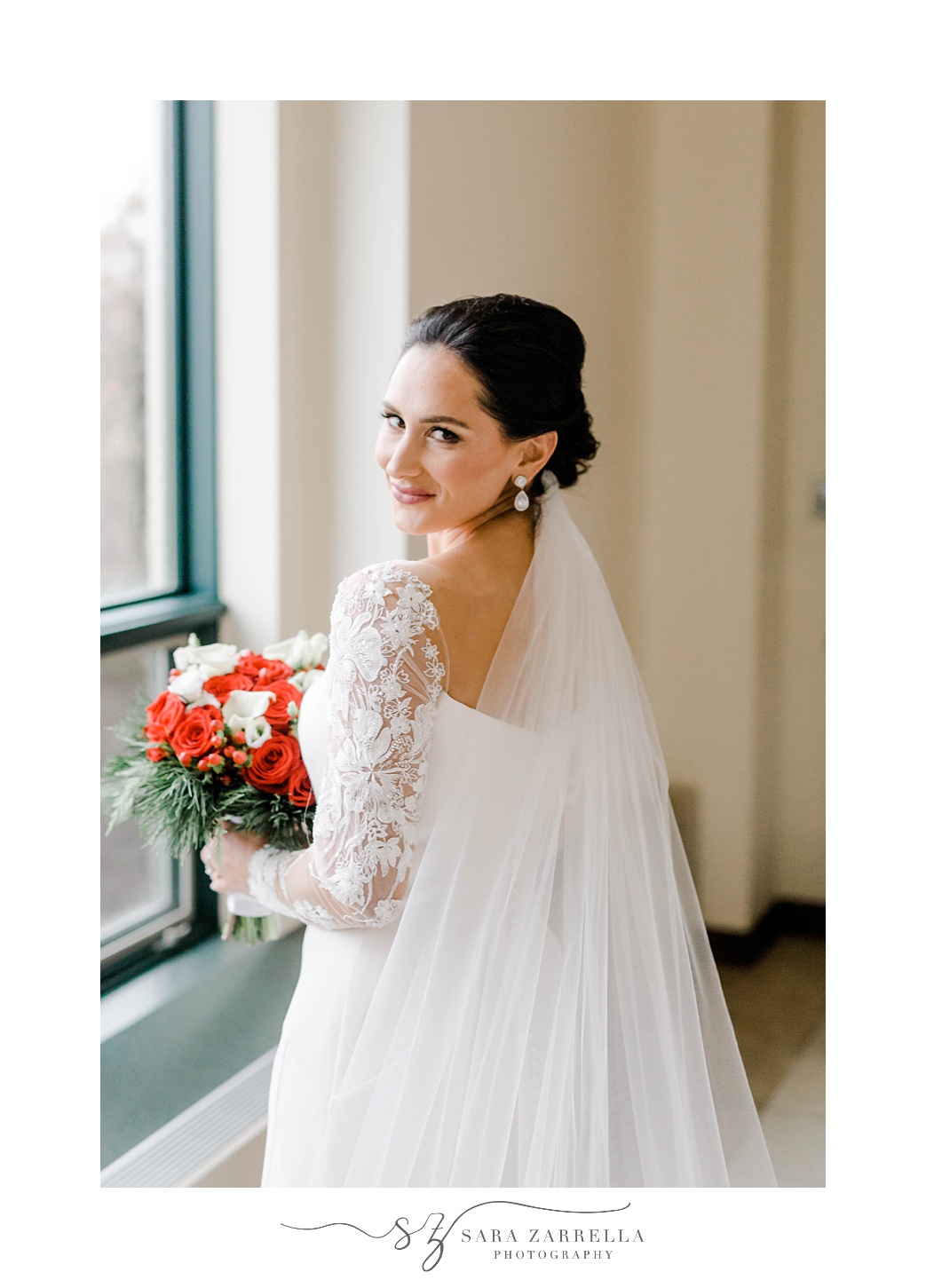 bride smiles looking over shoulder with veil draped around her 