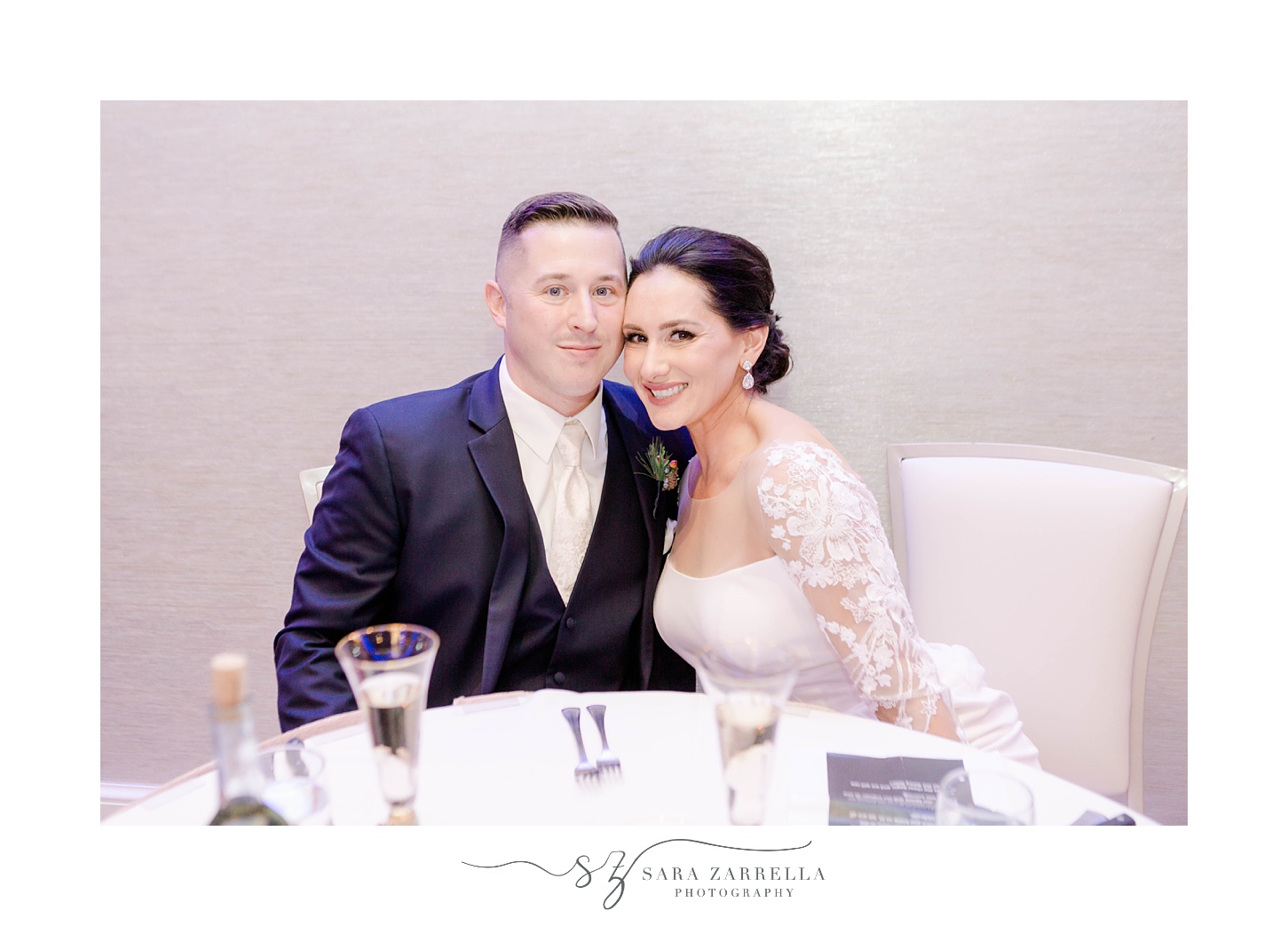 newlyweds sit at sweetheart table during RI wedding reception