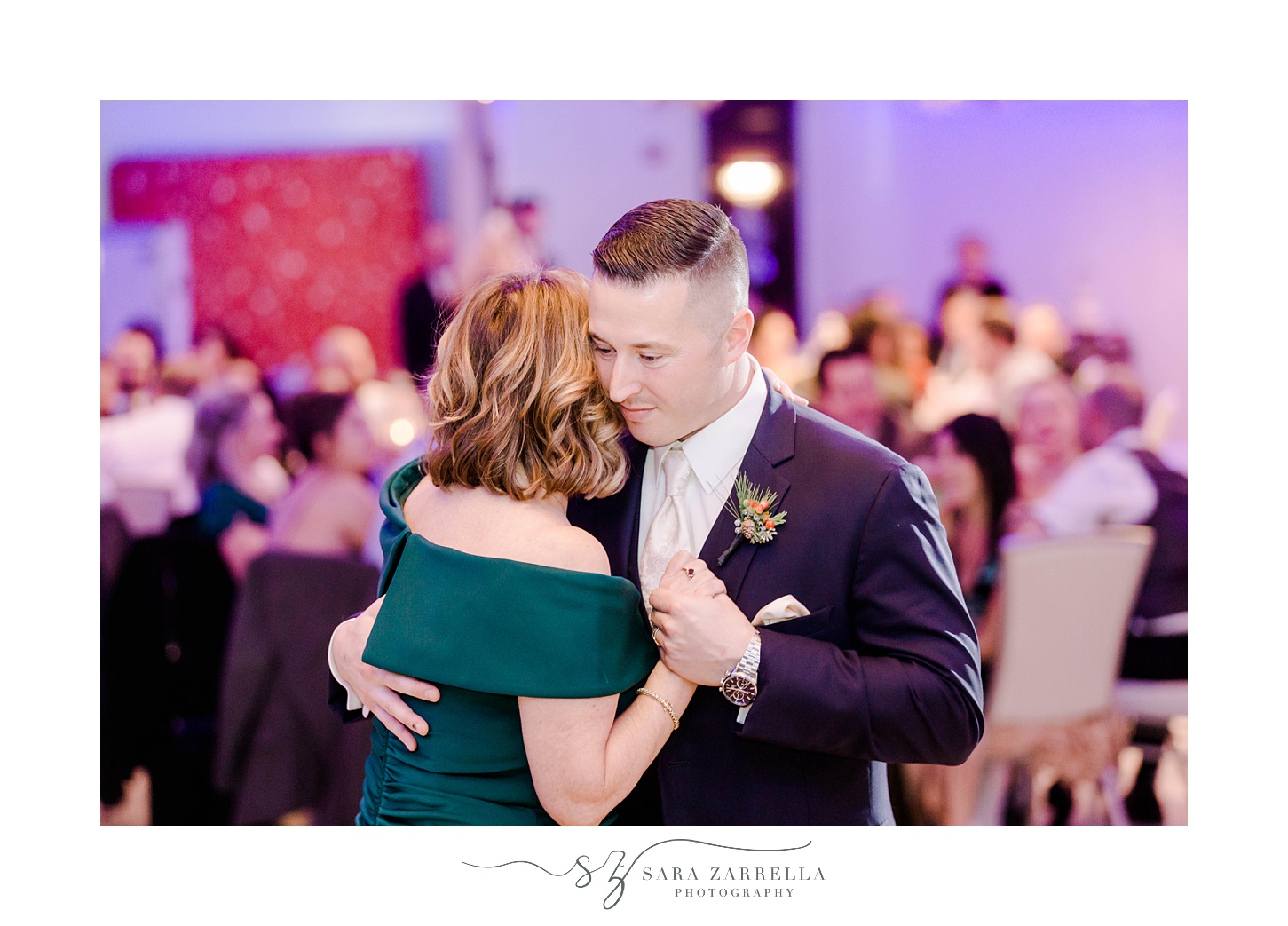 groom hugs mother to him during dance at winter wedding reception